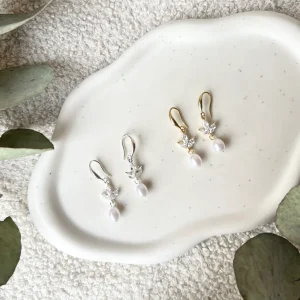 Glänzende Ohrringe mit feinen Details und weißen Perlen